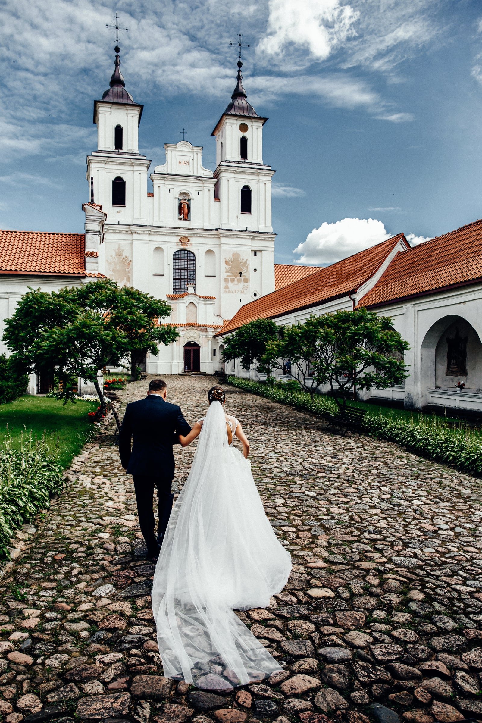 Jaunieji eina akmenimis grįstu taku link Tytuvėnų bažnyčios